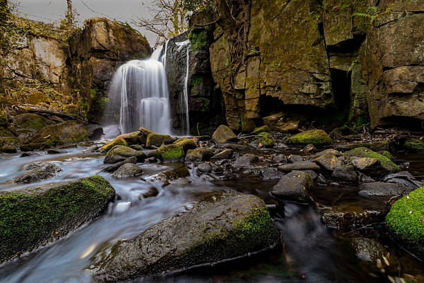 istock Waterfall cascading over mossy rocks in a peaceful forest 2210912390