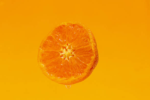 istock Half cut mandarin oranges isolated on a orange background. 2210915446