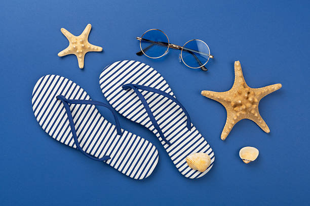 istock Striped blue flip flops with accessories on color background, top view 2210917833