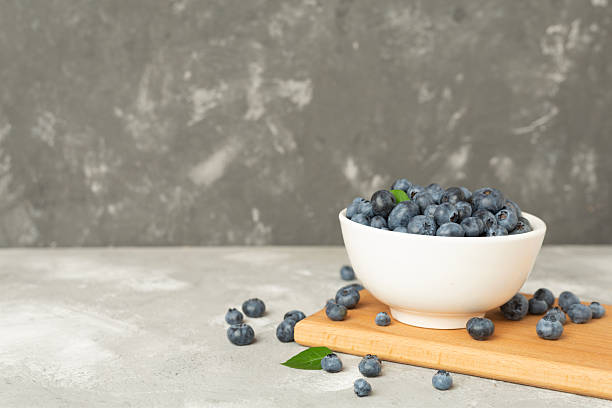 istock Bowl with fresh blueberries on concrete background 2210918468