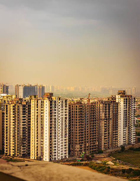 A striking urban scene showcasing modern high-rise residential towers set against a dramatic, moody sky in Noida, India. This dynamic composition captures the essence of rapid urban development, city life, and architectural growth in one of India’s fastest-growing metropolitan regions