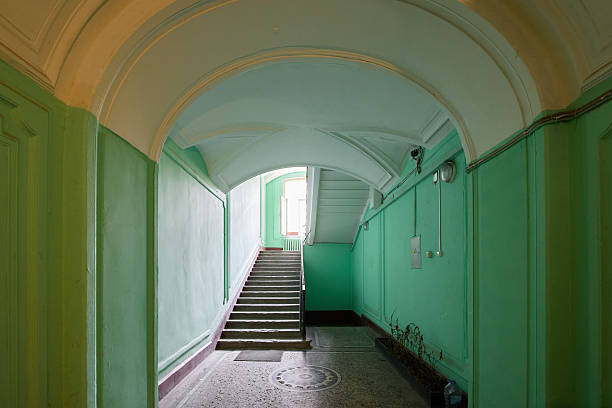 A beautifully serene architectural corridor, showcasing a stylish staircase and adorned with soft green tones