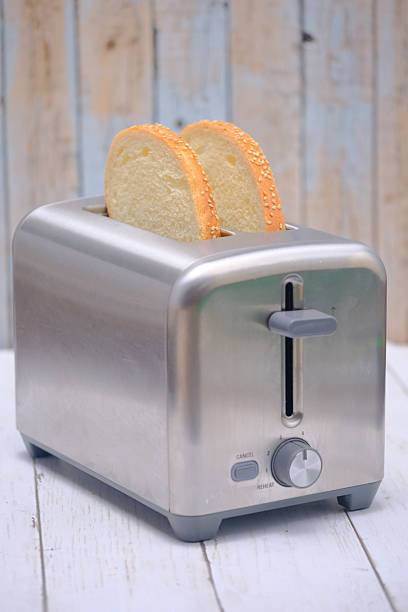 Roasted toasts popping out of a white toaster, isolated on white background