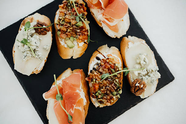Gourmet bruschetta platter with assorted toppings served on a slate board