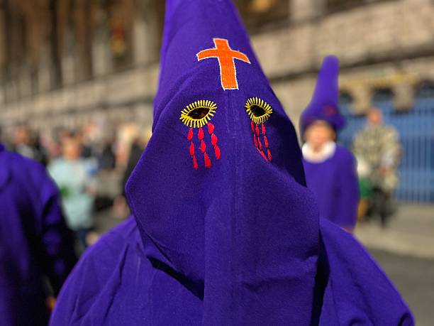 Quito, Pichincha, Ecuador - April 17, 2025: Cucurucho dressed in purple robes and a mask adorned with embroidered tears, participating in a vibrant procession in Quito, Ecuador, honoring the traditions of Holy Week