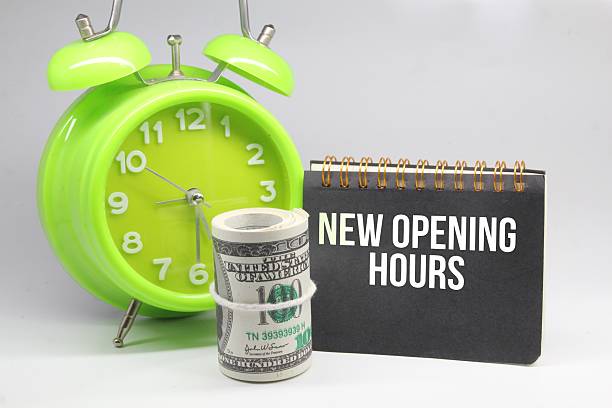 istock bell clocks, banknotes and notebooks with the word new opening hours 2210955713