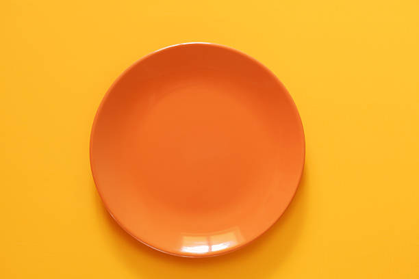 istock Empty Orange Ceramic Plate on Yellow background. Top view, copy space. Spring and Summer Menu 2210957667
