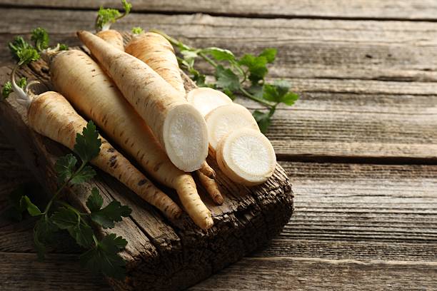 istock Parsley roots and leaves on wooden table, closeup. Space for text 2210960620