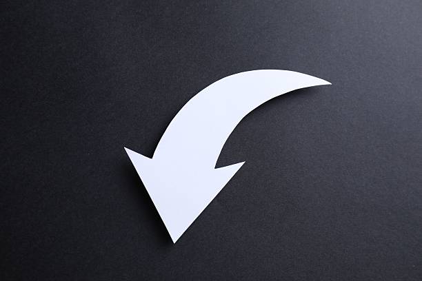One white paper arrow on black background, top view