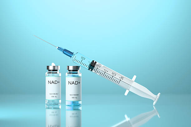 istock Medical syringe with a needle and a vials with NAD solution on blue background. 2210964873