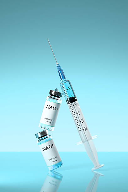 istock NAD solution in bottles for injection and syringe on on blue background. 2210964876