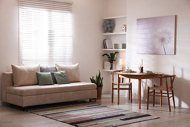 istock Stylish table setting, chairs and sofa in dining room. interior design 2210966525