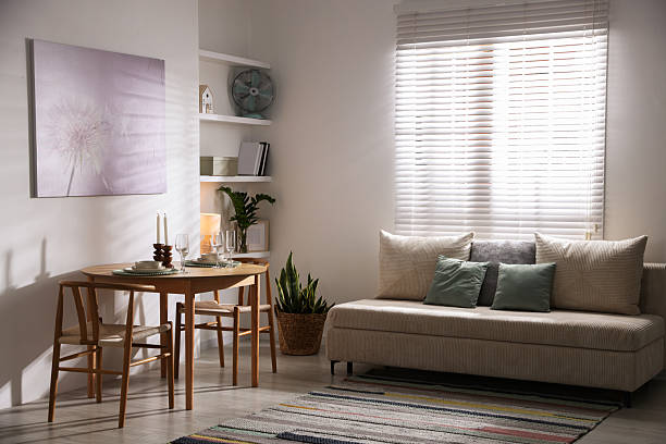 istock Stylish table setting, chairs and sofa in dining room. interior design 2210966527