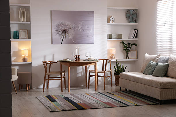 istock Stylish table setting, chairs and sofa in dining room. interior design 2210966531