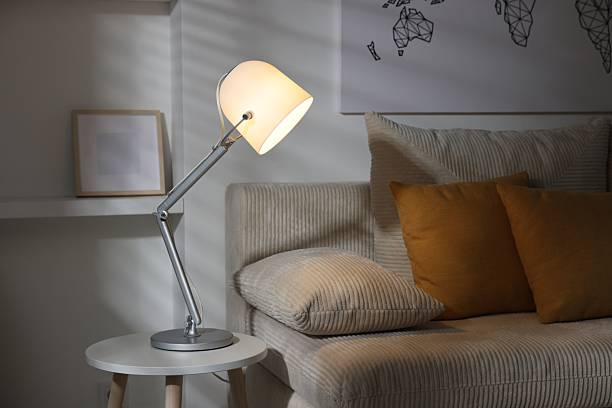 istock Stylish night lamp on side table near sofa in room. Interior design 2210966545