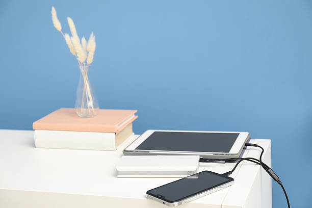istock USB charge cable connected to devices on shelf near light blue wall 2210967846