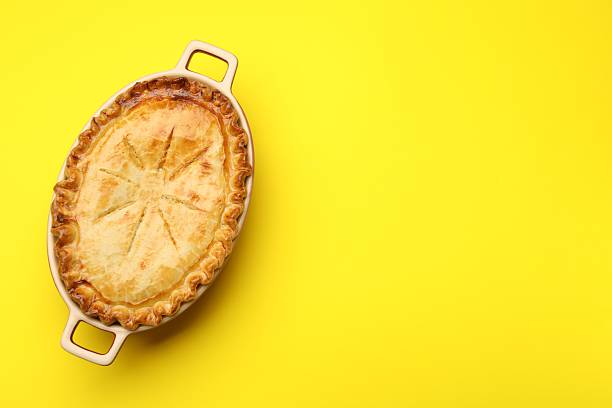 istock Delicious fresh homemade pie on yellow background, top view. Space for text 2210968206