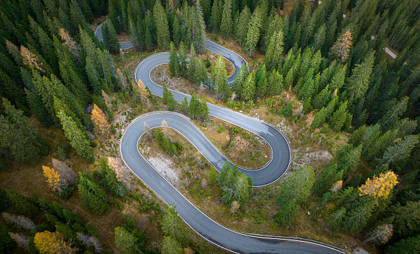 istock Winding road between the greenforest - aerial view 2210968352