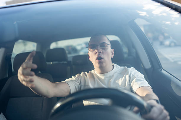 istock Man Expressing Frustration While Driving in Urban Traffic Setting 2210969090