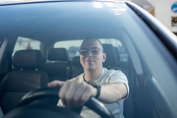 istock Confident Driver Behind the Wheel of a Moderately Lit Car 2210969133