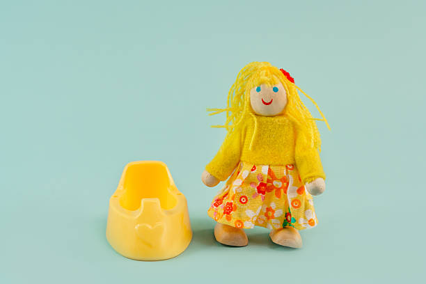 istock Toy girl child with a potty on a blue background, potty training 2210970141