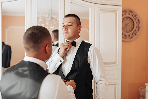 istock Two men are getting dressed up in a bedroom 2210980351