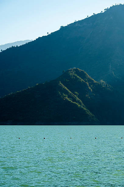 istock Sunlight illuminates the green mountains, casting reflections on the lake below. The scene embodies the beauty of nature and creates a peaceful atmosphere. 2210980891