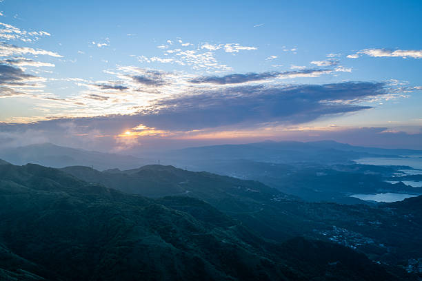 Experience the beauty of Ruifang, Taiwan, where the spring sunset paints the sky as clouds drift across the mountain and ocean vistas.