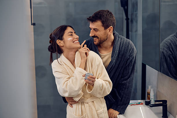 istock Embraced couple having fun with face cream in the bathroom. 2210995967