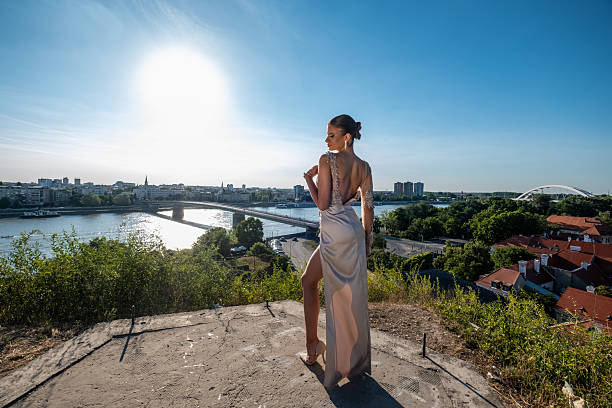 Beautiful young woman in a formal dress, posing at the observation deck, ceremony, prom night