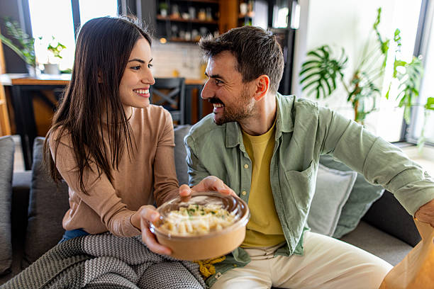 istock Couple sharing a takeaway meal at home 2211004036
