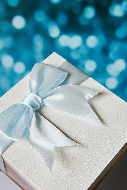 istock White luxury gift box with ribbon bow on soft blue bokeh background perfect for elegant gift presentations 2211004295
