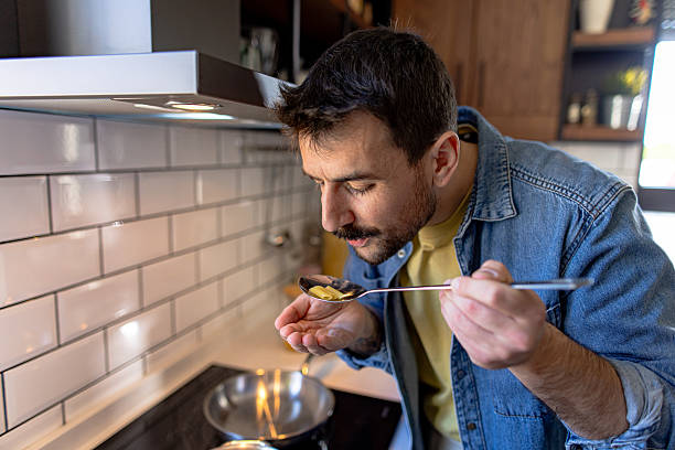 istock Chef smelling and tasting food from spoon in kitchen 2211004765