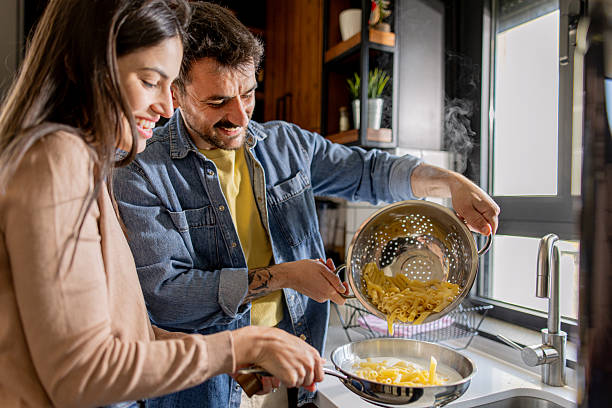 istock Couple cooking pasta together in modern kitchen 2211005886