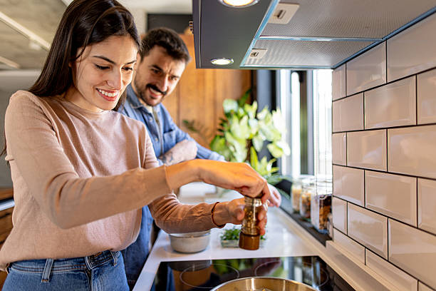 istock Couple Cooking Together in Modern Kitchen, Adding Spices to Their Meal 2211005887