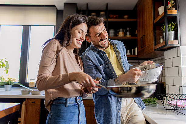 istock Happy couple cooking together in modern kitchen 2211005913