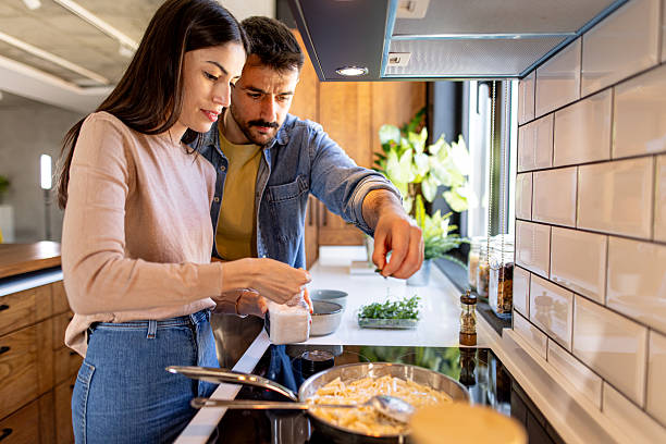 istock Young couple cooking pasta together in modern kitchen 2211005959