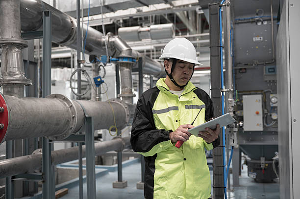 istock Asian Engineer Performing Pipe System Inspection in Modern Industrial Facility 2211006195