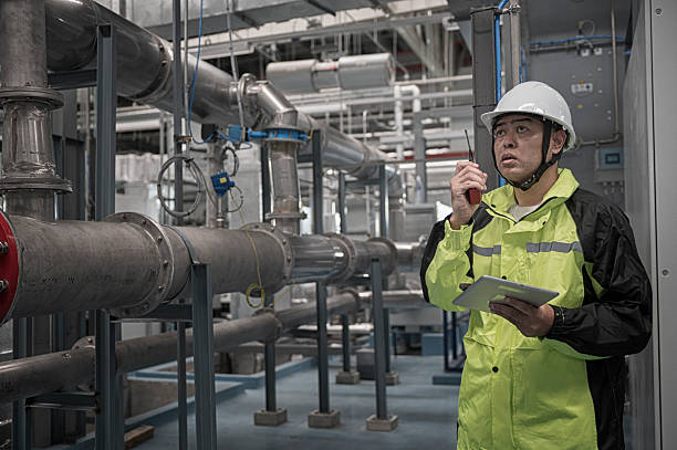 istock Asian Engineer Performing Pipe System Inspection in Modern Industrial Facility 2211006199