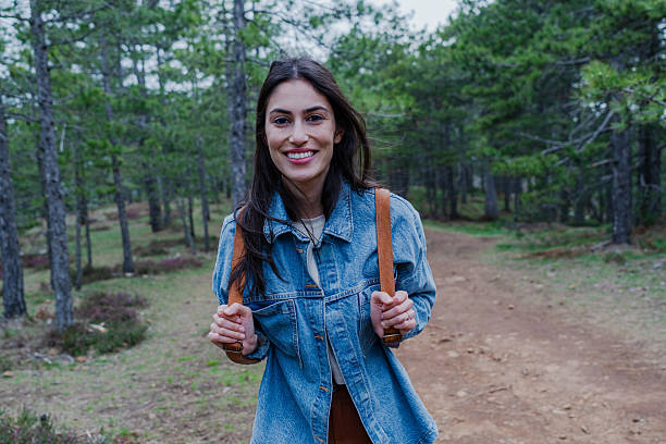 istock Young Woman Hiking and Smiling in a Forest Path 2211006903