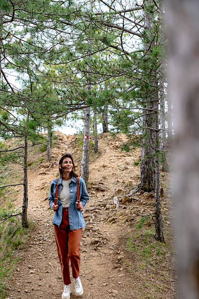 istock Young woman walking on a path in the forest enjoying the hike 2211007009