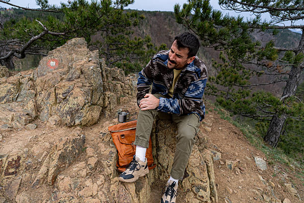 istock Hiker experiencing knee pain while resting on a rock during a mountain trek 2211007245