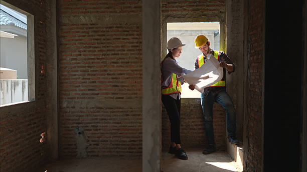 istock Architects and engineers work together to assess the residential home construction site's progress 2211008090