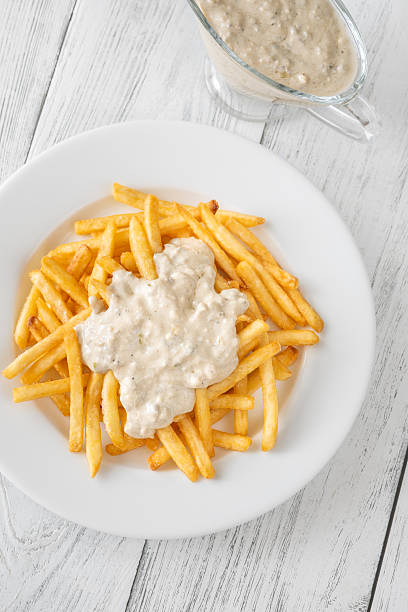 Golden fries drizzled with rich blue cheese sauce on white plate