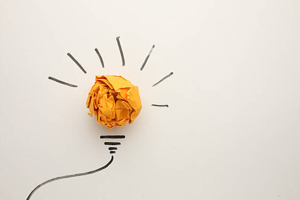 istock Creative thinking ideas and innovation concept. Paper scrap ball yellow colour with light bulb symbol on white background 2211016473