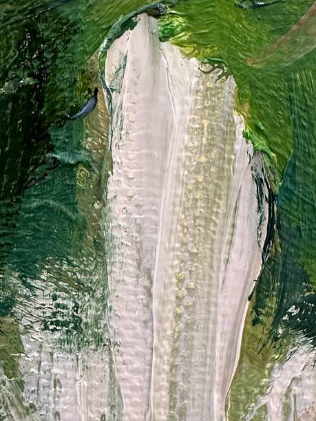 A close-up fragment of an abstract impasto painting is dominated by thick strokes of white and green paint. The white paint is applied in broad, vertical movements, creating a sense of volume and relief. Green strokes surround the white, varying from dark, saturated hues to lighter, blurred tones, adding depth to the composition. The paint texture is highly expressive, with distinct traces of the brush and palette knife forming an uneven, dynamic surface. The contrast between the dense white strokes and the surrounding greens creates visual interest and emphasizes the tactile quality of the painting.