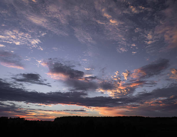 A tranquil sunset sky painted with soft pastel hues and delicate cloud textures. The gentle interplay of warm and cool tones creates a dreamy and peaceful atmosphere.