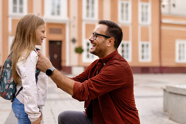 istock Father and Schoolgirl Bonding Outside Elementary School 2211019878