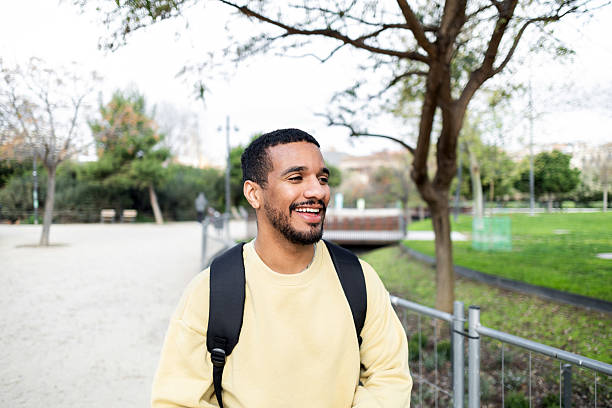 istock Smiling man walking in urban park enjoying sunny day 2211024218