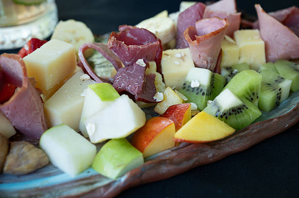 istock Delicious Charcuterie Board Presenting Cured Meat, Cheese, and Fresh Fruit 2211024910